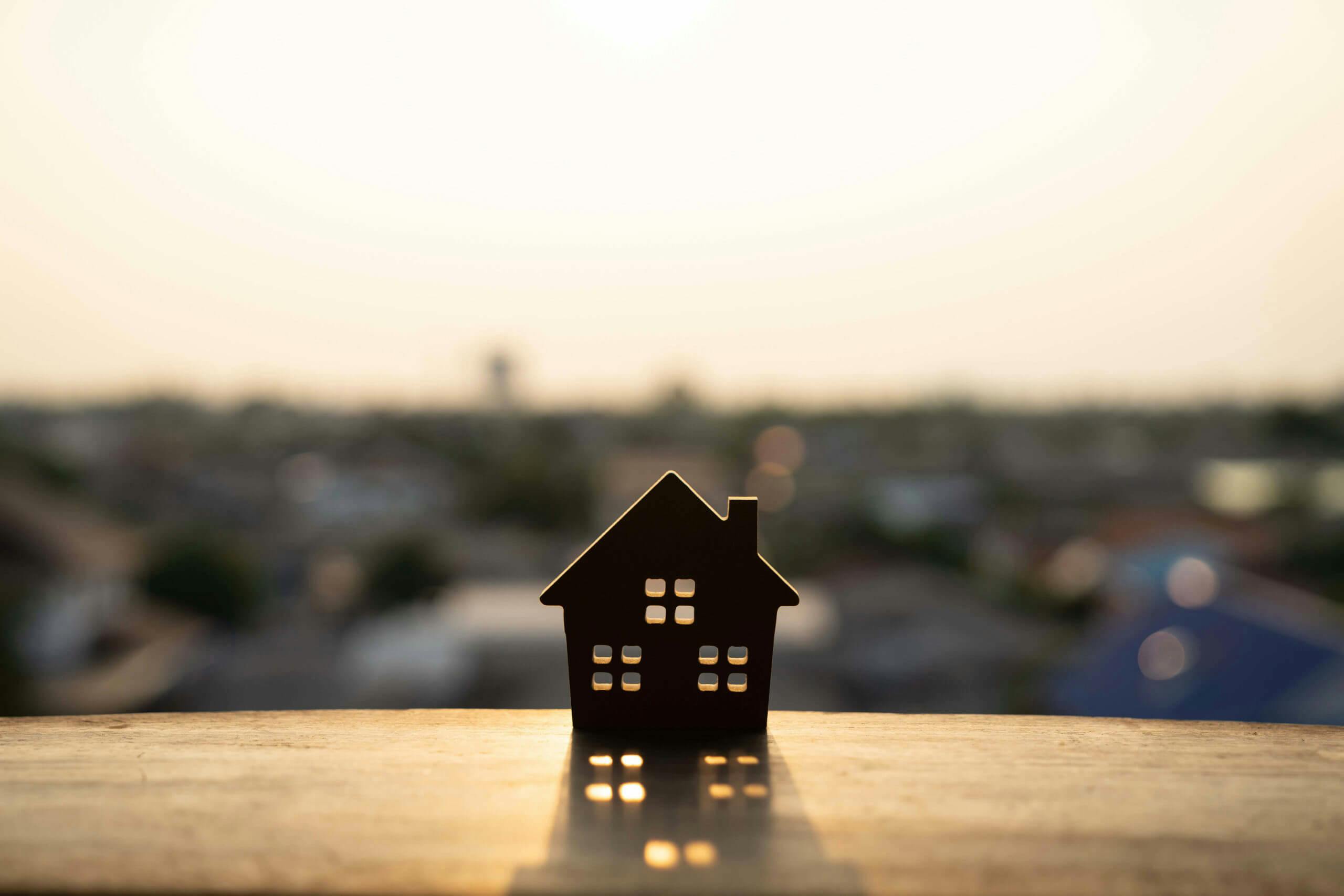 Miniature house situated on a patio edge overlooking city