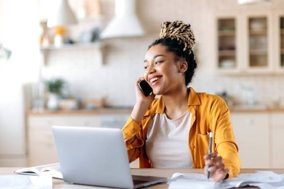 Real estate agent talking on the phone in front of her computer