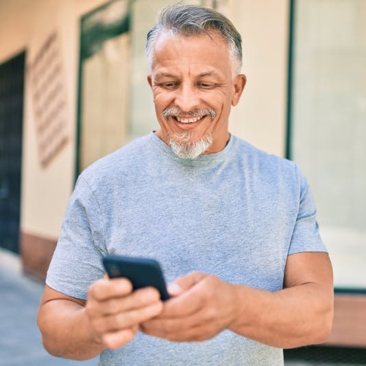 Man smiling while holding his phone