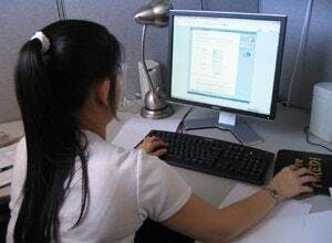 Teen girl at a computer, taking an online drivers ed course.