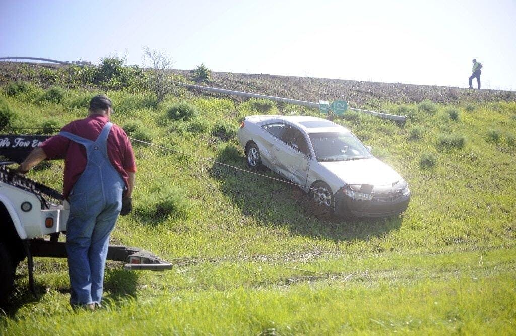 Gary Kimbell, left, of CM Tow works remove a car from the side of westbound Highway 12 in Fairfield, Sunday.  (Adam Smith/Daily Republic)