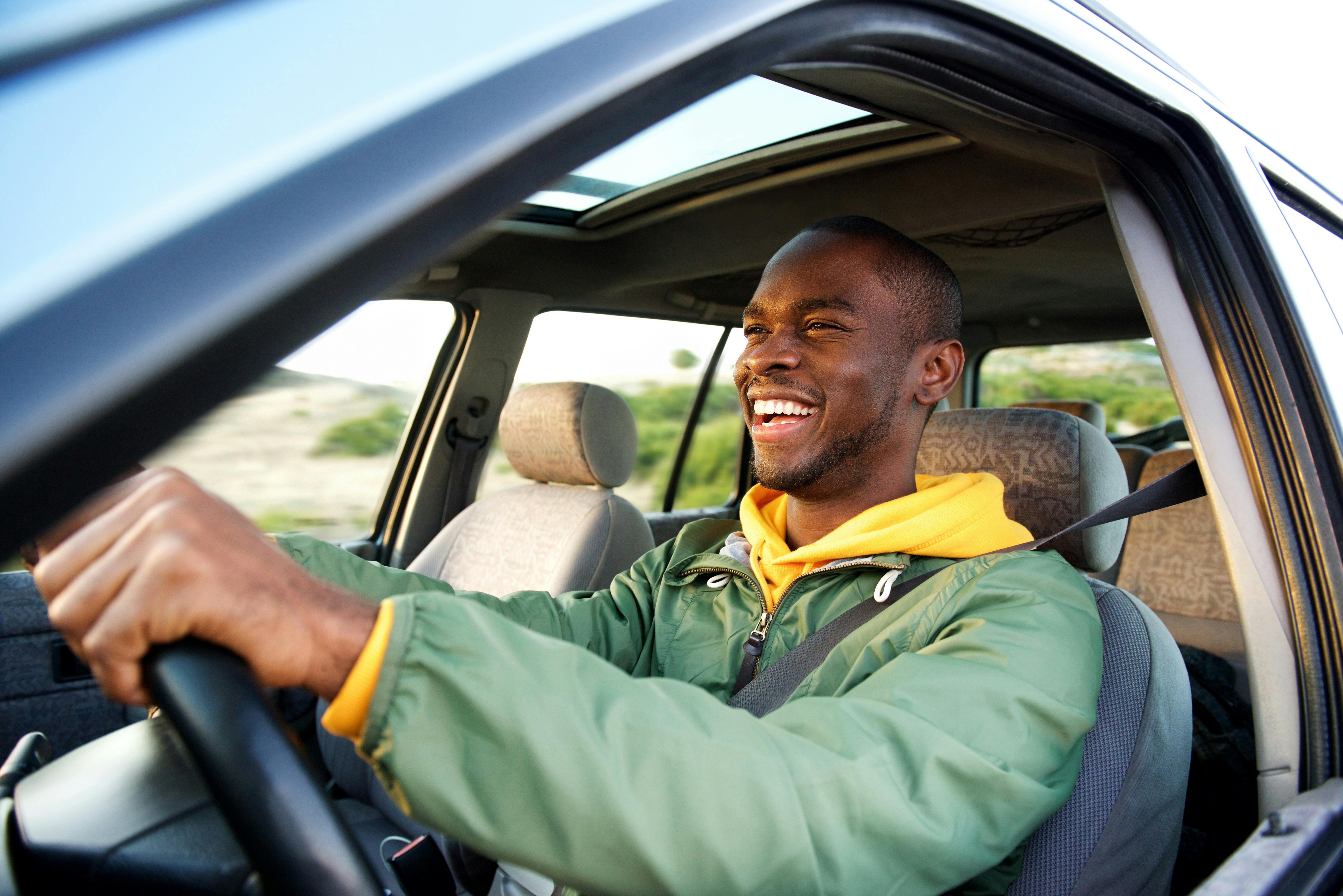 Man smiling, while driving a vehicle