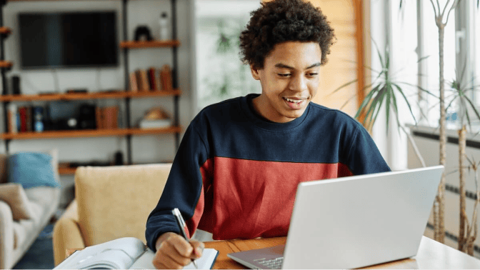 Teenage boy taking an online class on his laptop