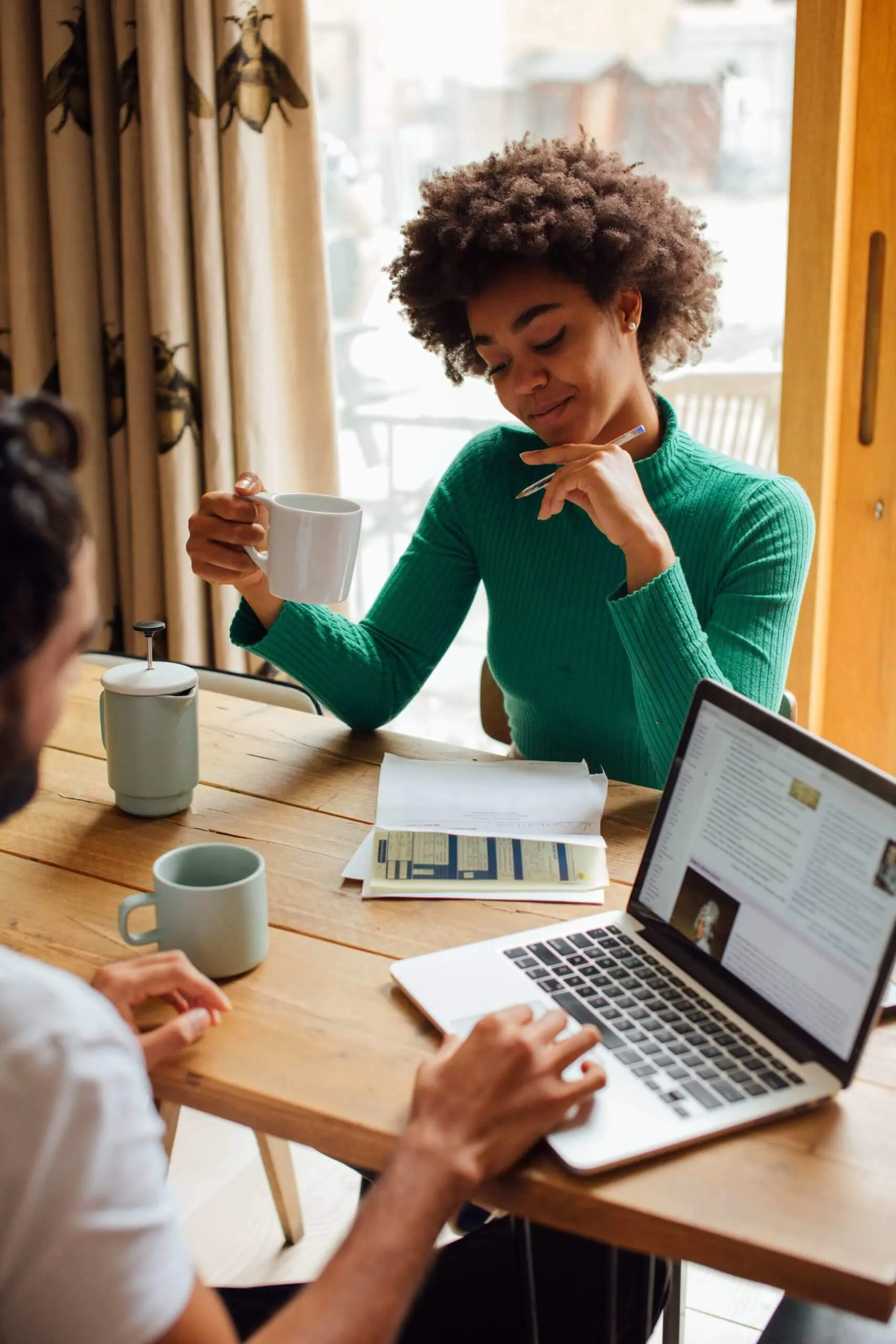 woman at table with man on computer