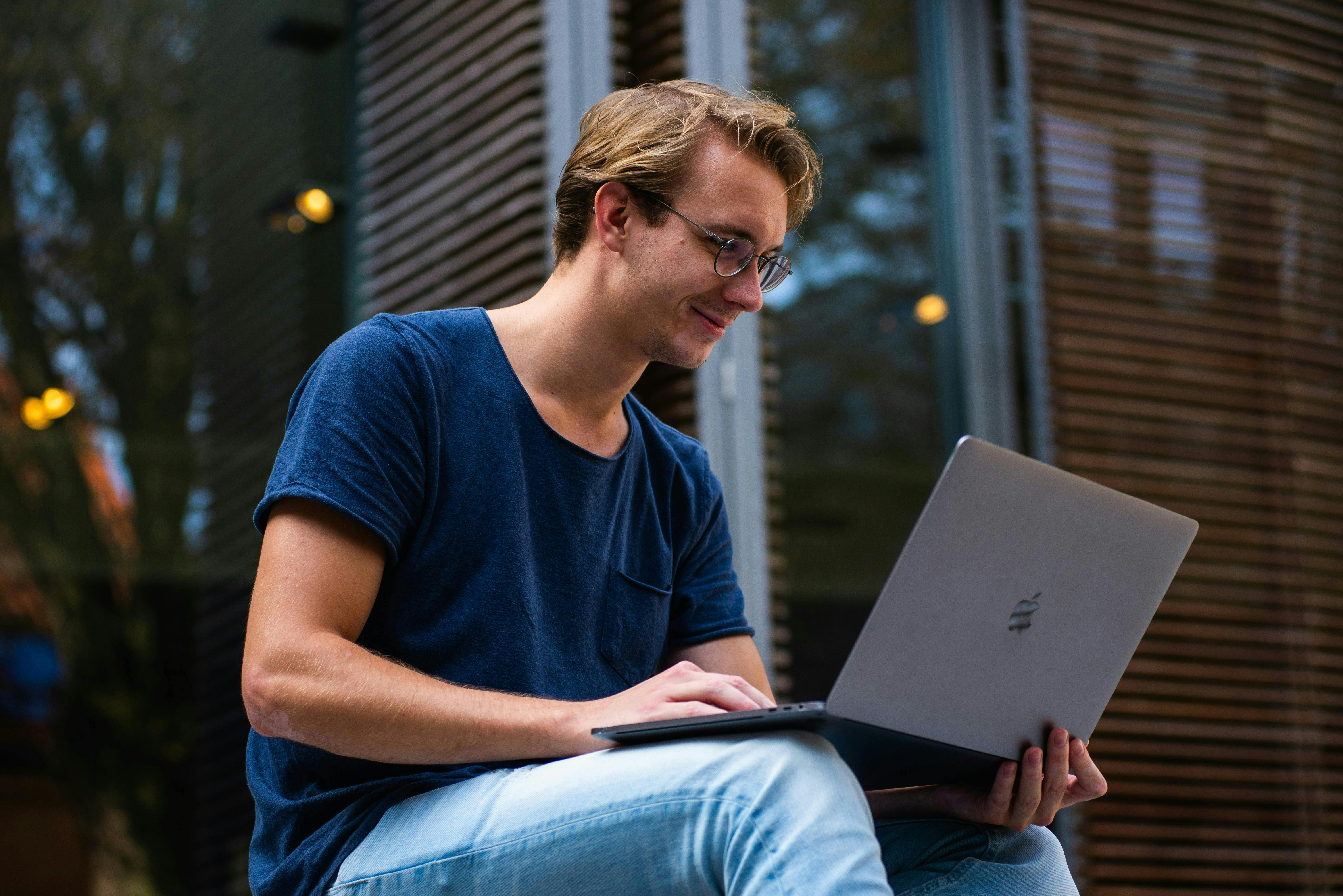 man in blue shirt working on computer