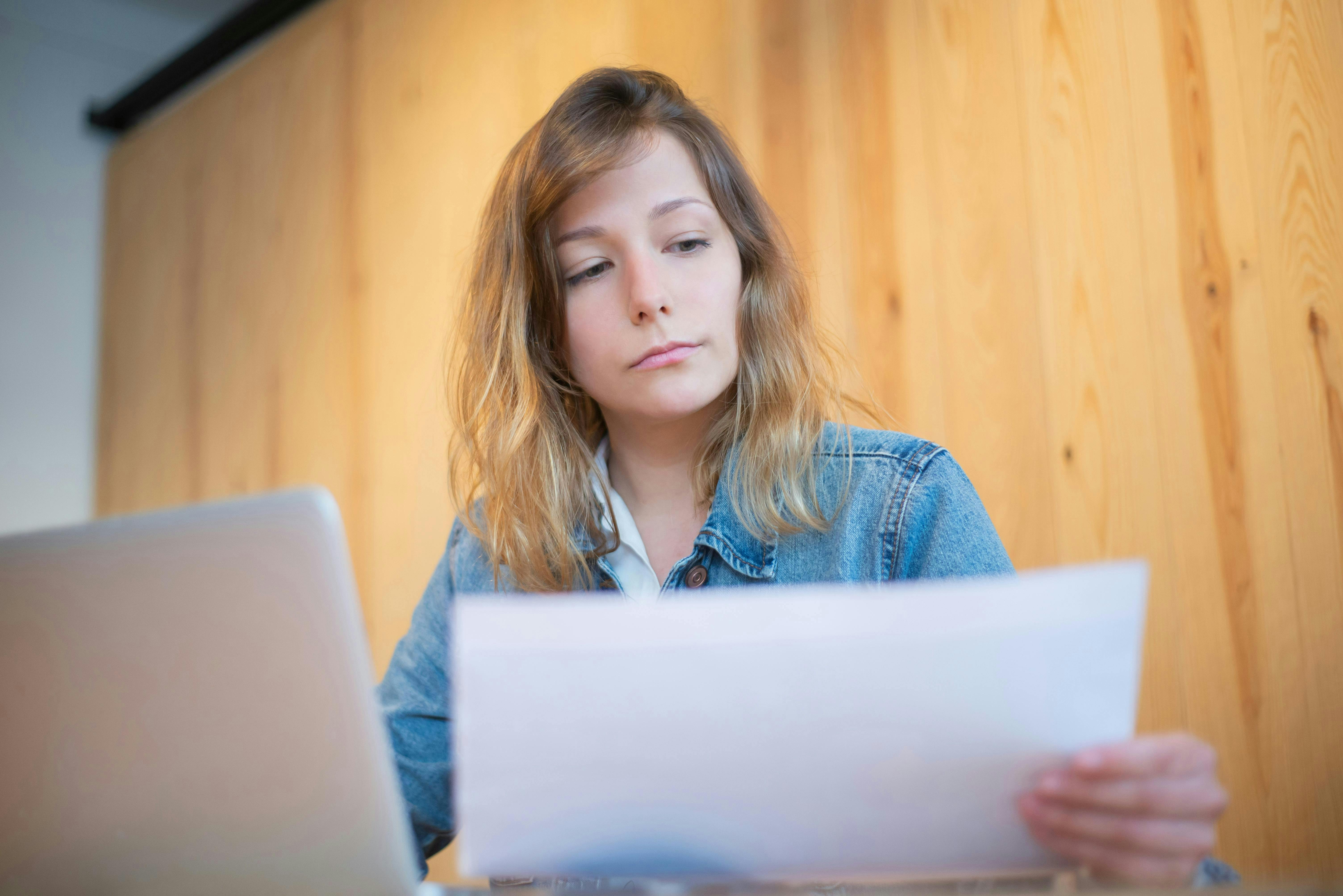 lady at a desk on her computer looking a paper
