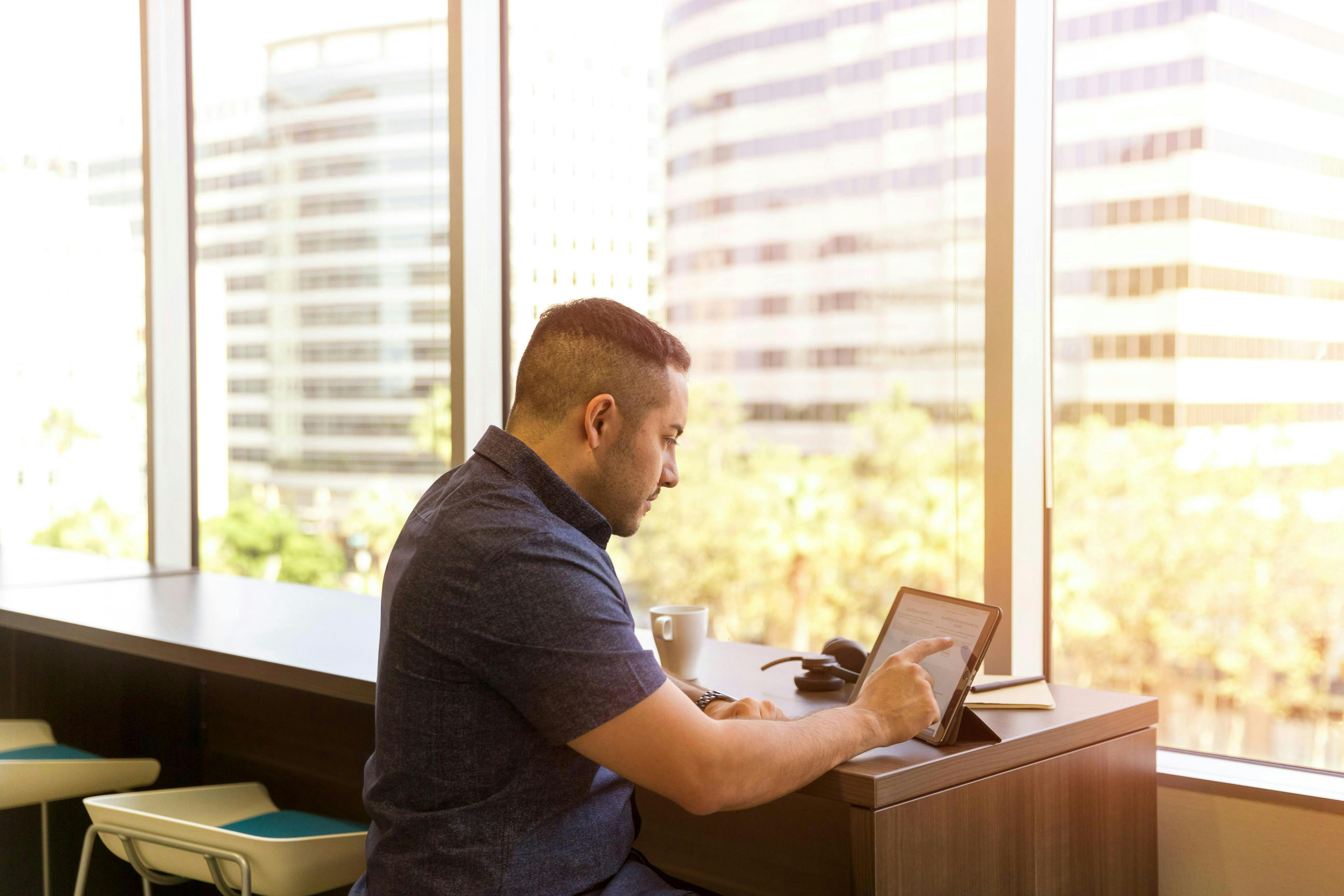 man at ipad at a desk