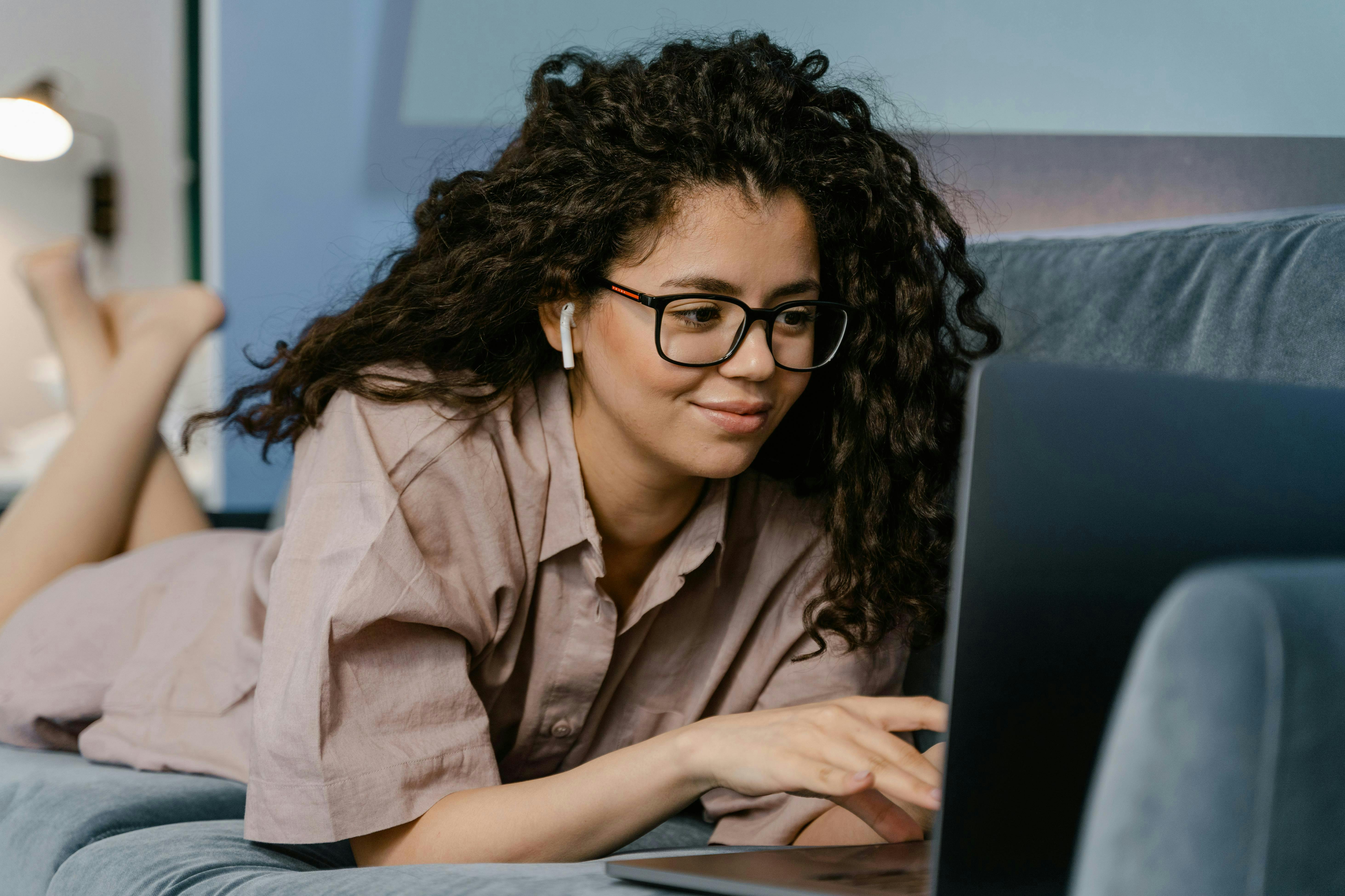 woman on her couch on the computer