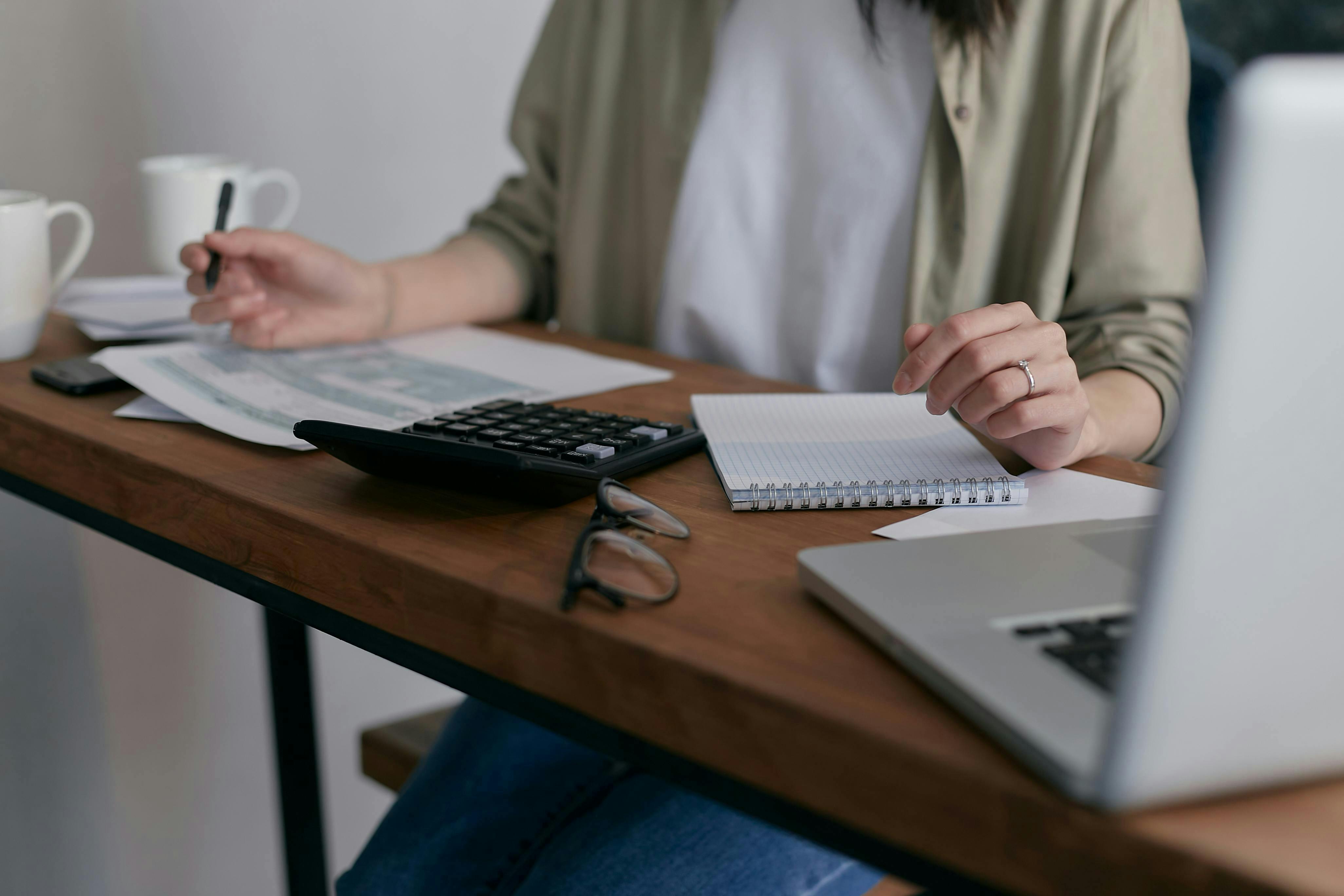 person working at their desk with calculator