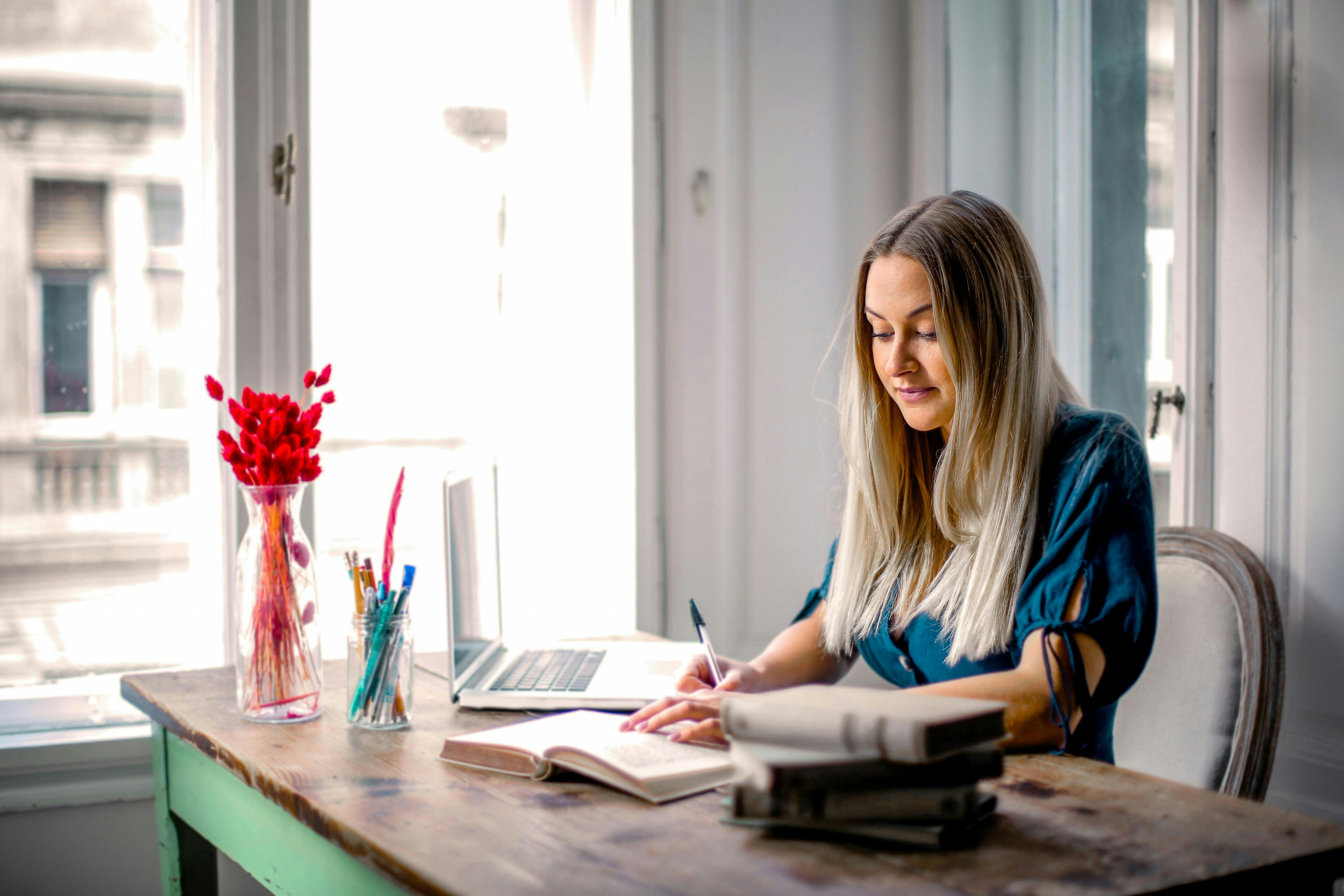 lady at her desk in an office writing in a journal