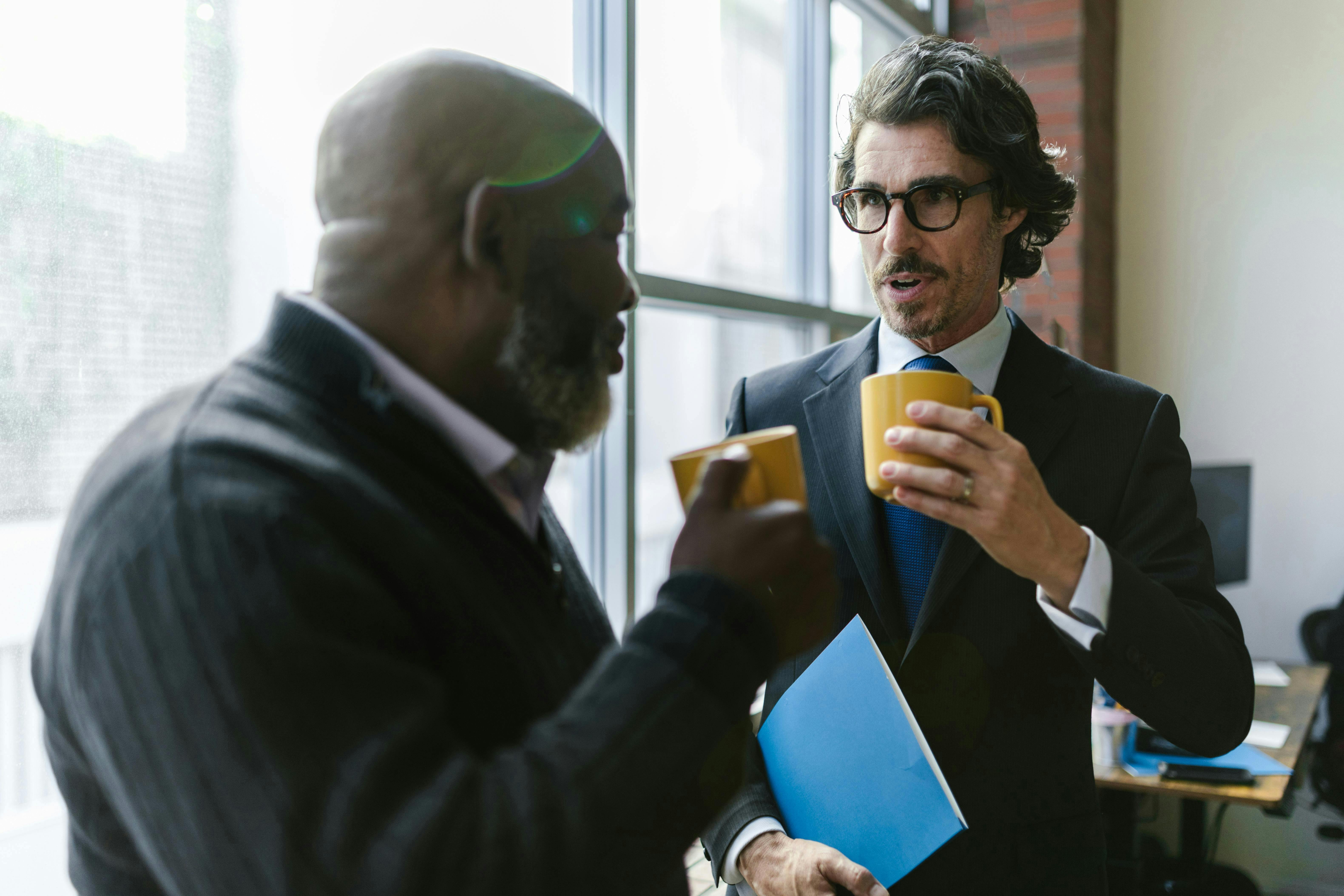 two men in a office talking to each other