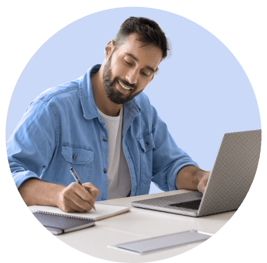Man taking notes in front of a laptop