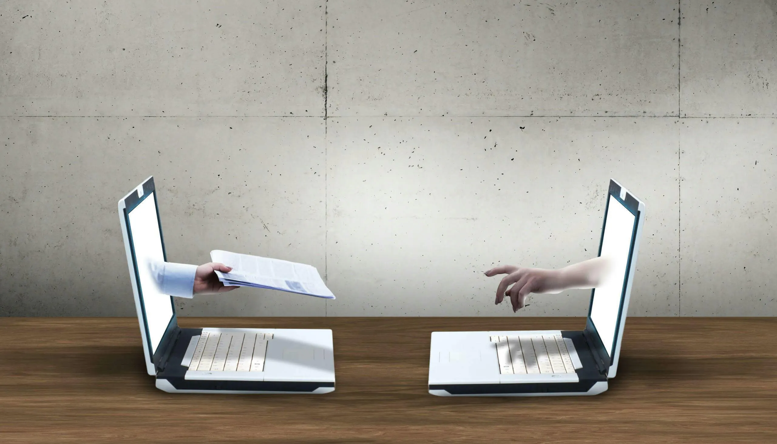 two laptops with hands coming out of them