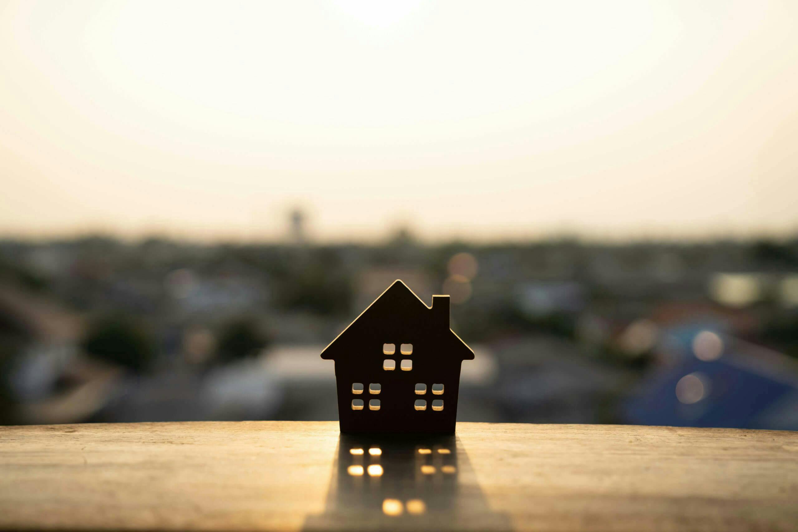 Miniature house situated on a patio edge overlooking city