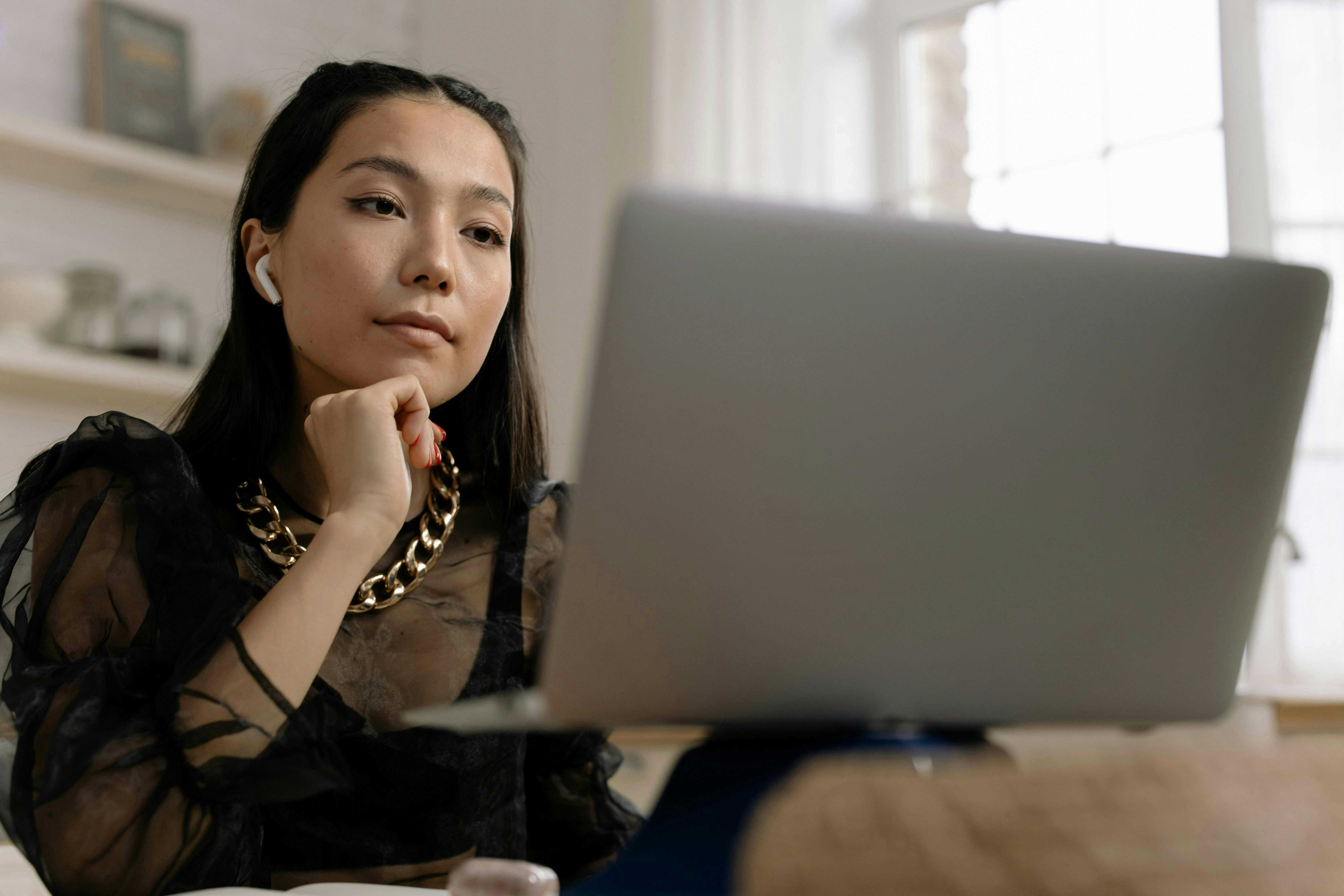 woman with airpods in with her computer
