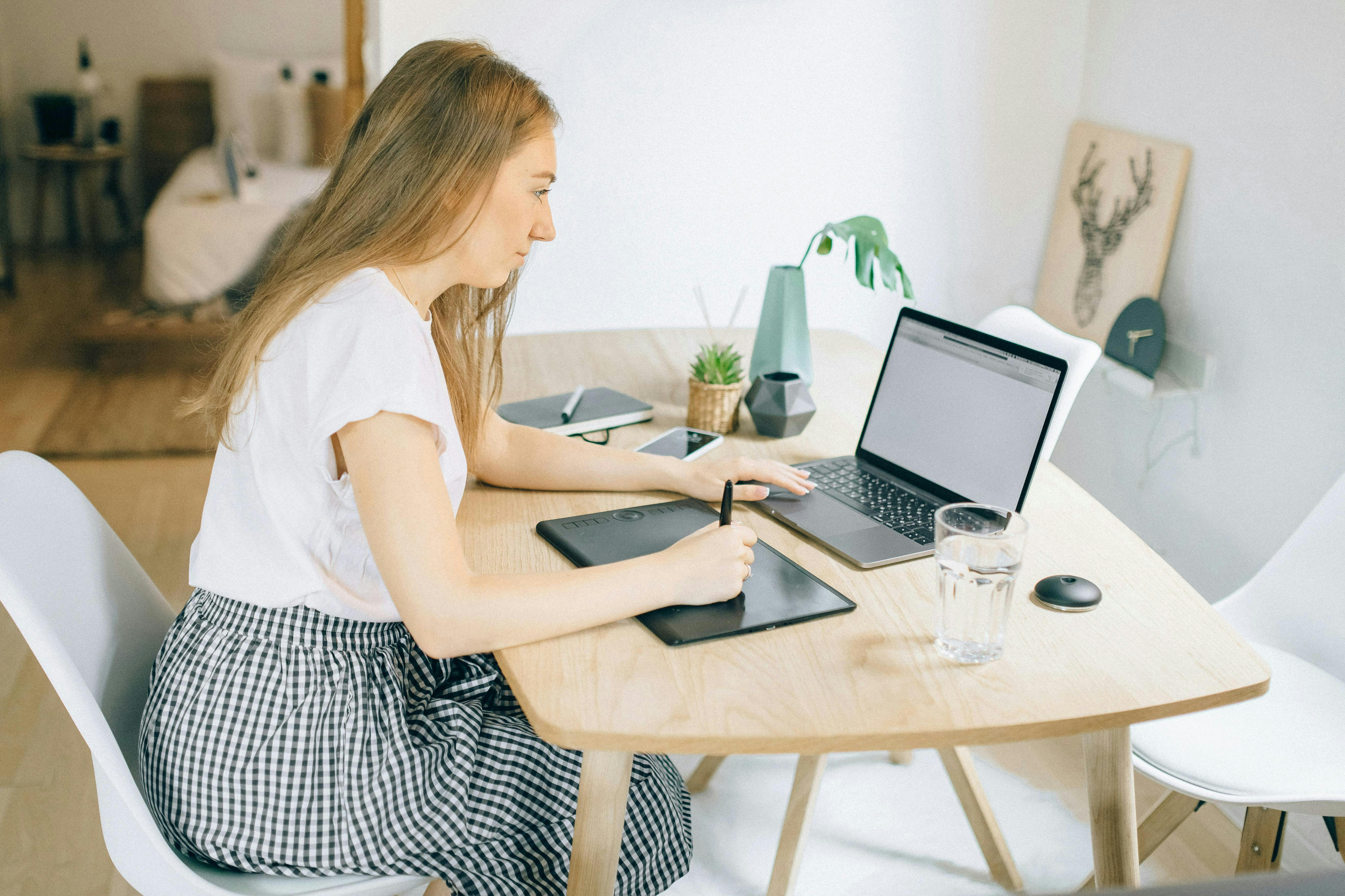 woman at her desk with her laptop and water