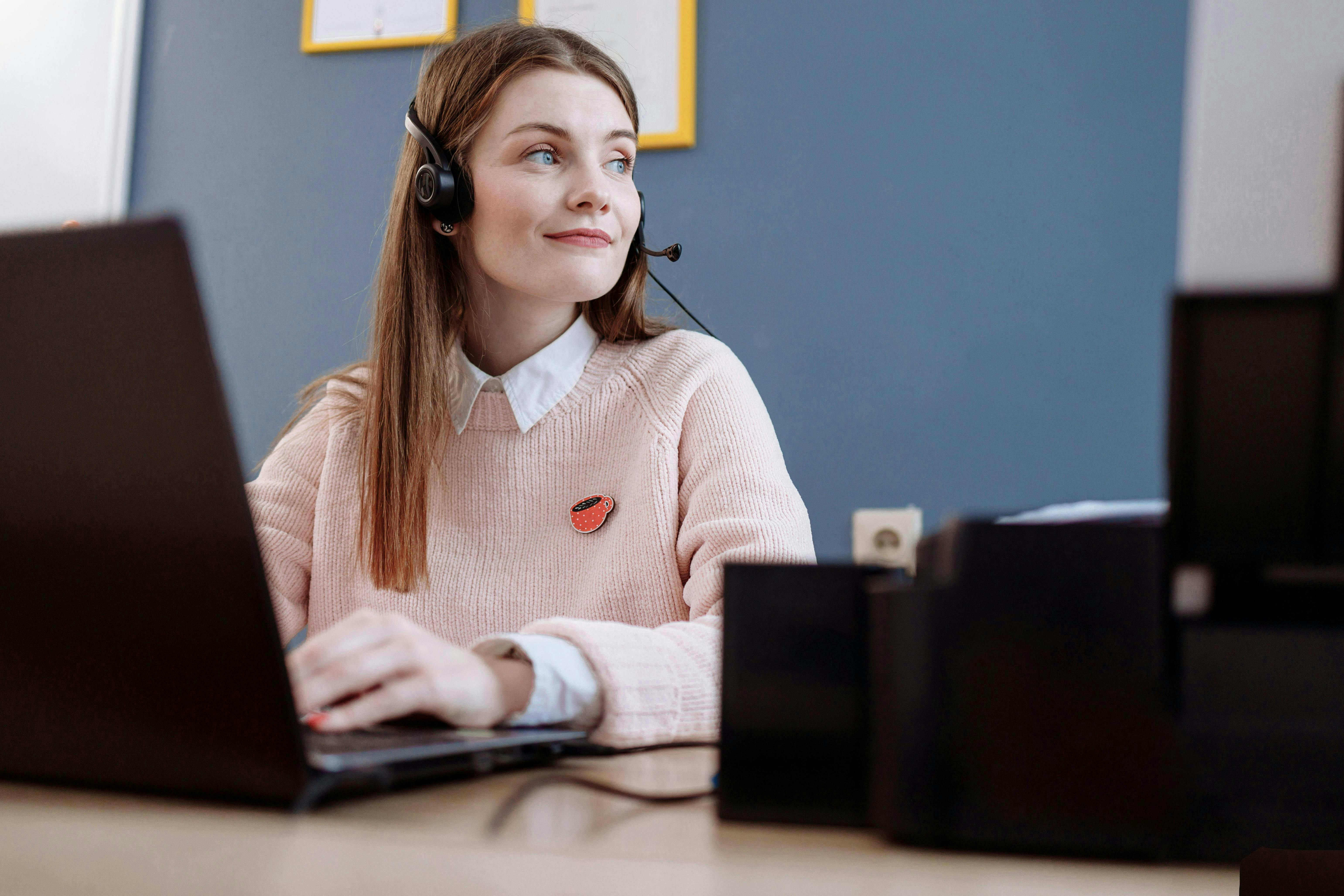 woman looking away from computer smiling